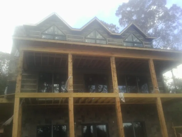 Dormers and porch framing on a large log home under construction — Roof Coating work by our crew in Louisville